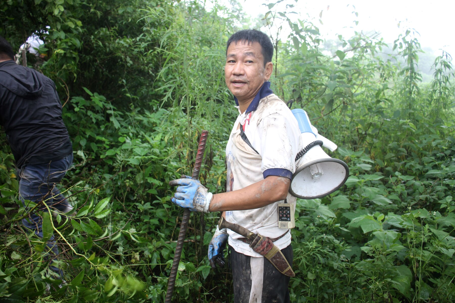 Mayor Harka clearing the bushes with his traditional khukuri, the curved knife used by Gurkha soldiers.