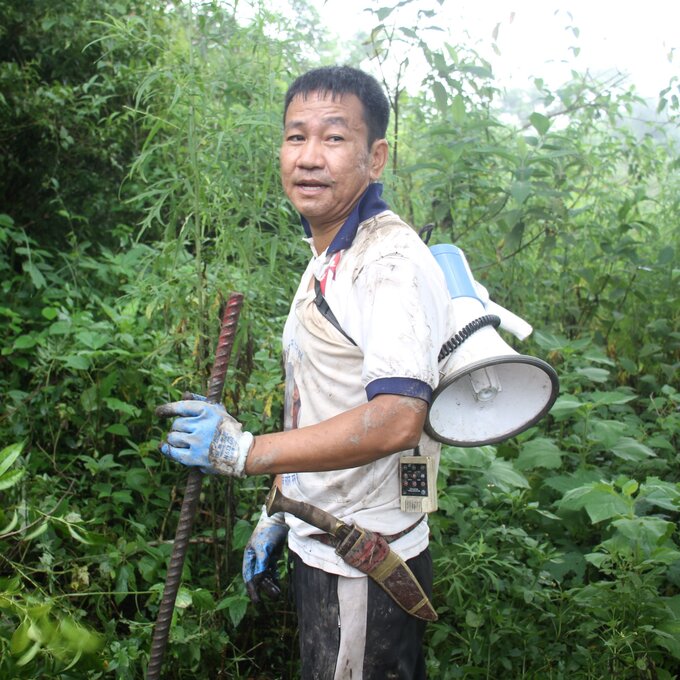 Mayor Harka clearing the bushes with his traditional khukuri, the curved knife used by Gurkha soldiers.